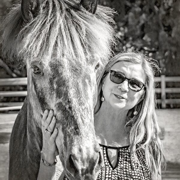 Portrait of Kimberly Hart with a pony at Sage Farms.
