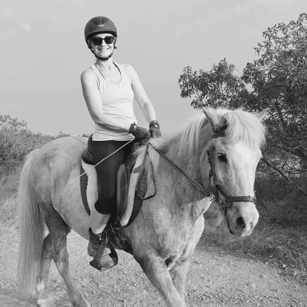 Portrait of Kati Exner-Zmolek riding a horse at Sage Farms.